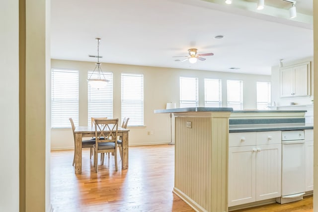 kitchen with light wood finished floors, plenty of natural light, baseboards, and ceiling fan