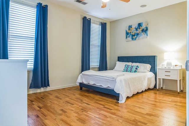 bedroom with light wood-style flooring, visible vents, and ceiling fan