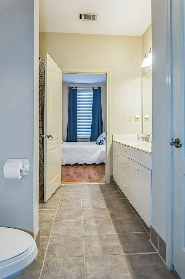 bathroom featuring tile patterned flooring, toilet, vanity, and visible vents
