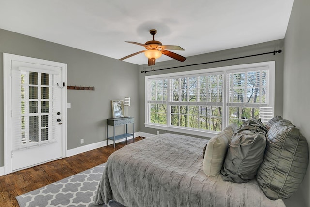 bedroom with wood finished floors, a ceiling fan, baseboards, and multiple windows