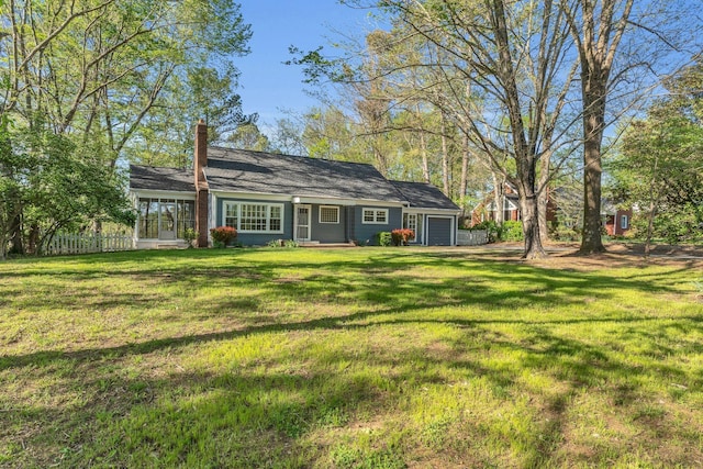 back of house with a garage, a yard, and fence