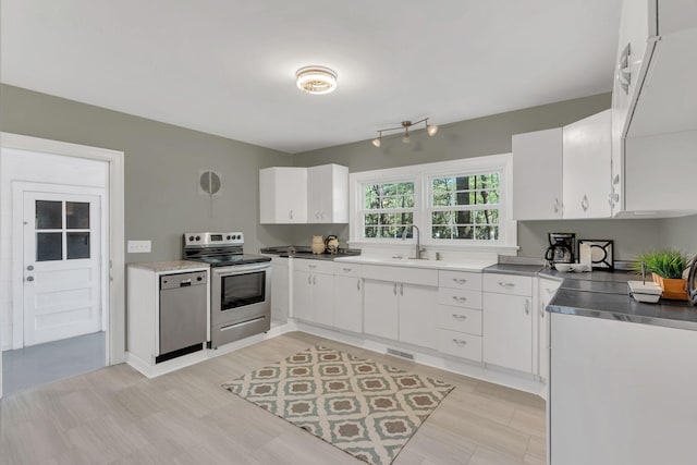 kitchen with white cabinets, stainless steel appliances, visible vents, and a sink