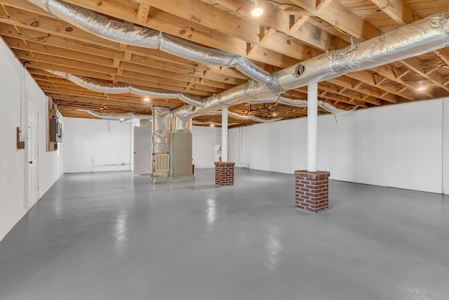 unfinished below grade area with heating unit and electric panel