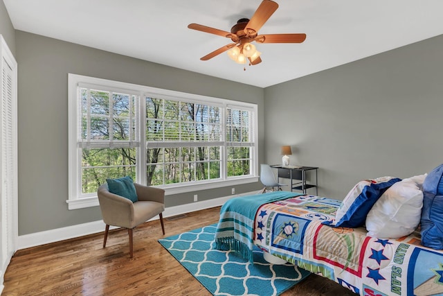 bedroom with wood finished floors, visible vents, baseboards, and multiple windows