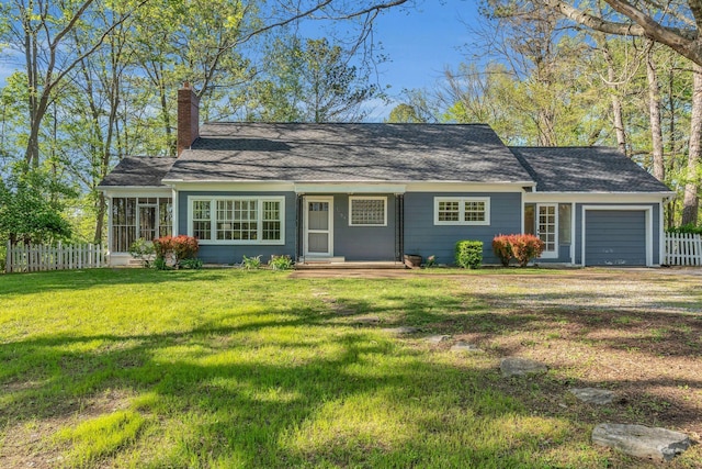 ranch-style house with roof with shingles, a chimney, fence, a garage, and a front yard