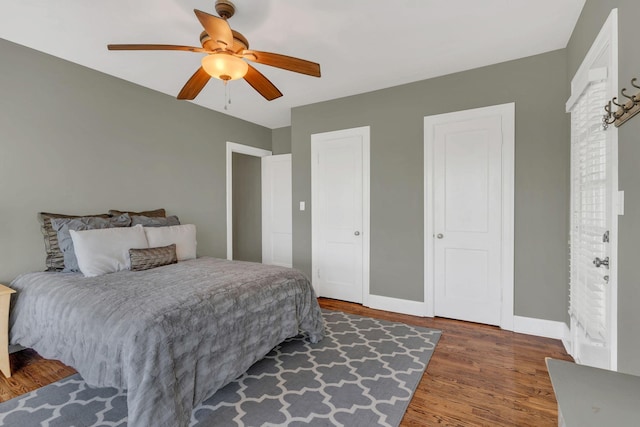 bedroom with baseboards, wood finished floors, and ceiling fan