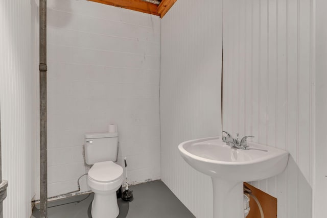 bathroom with concrete flooring and toilet