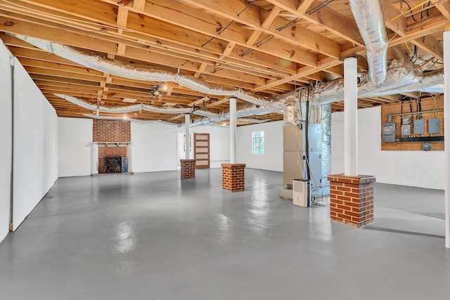 below grade area featuring a brick fireplace and heating unit
