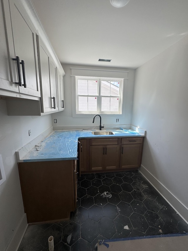 446 Roberts St, Murfreesboro, TN 37130 - kitchen featuring baseboards, dark tile patterned flooring, light countertops, and a sink