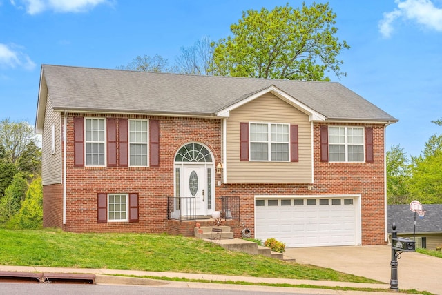 split foyer home featuring a shingled roof, driveway, brick siding, a front yard, and a garage