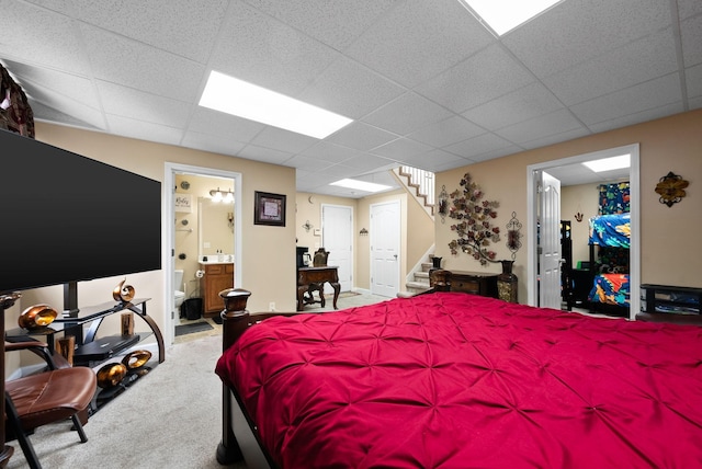 carpeted bedroom with ensuite bath and a paneled ceiling