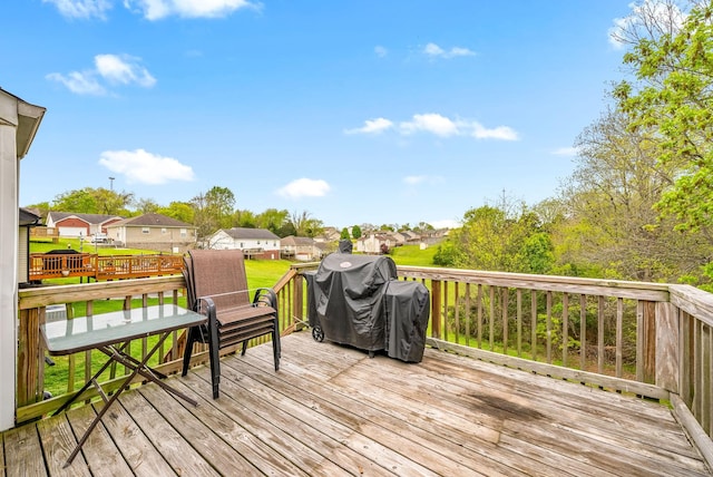 wooden terrace with a yard, a residential view, and area for grilling
