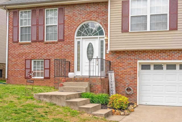 doorway to property featuring brick siding, concrete driveway, and a garage
