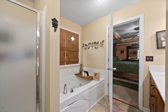ensuite bathroom with connected bathroom, a shower stall, vanity, and a jetted tub