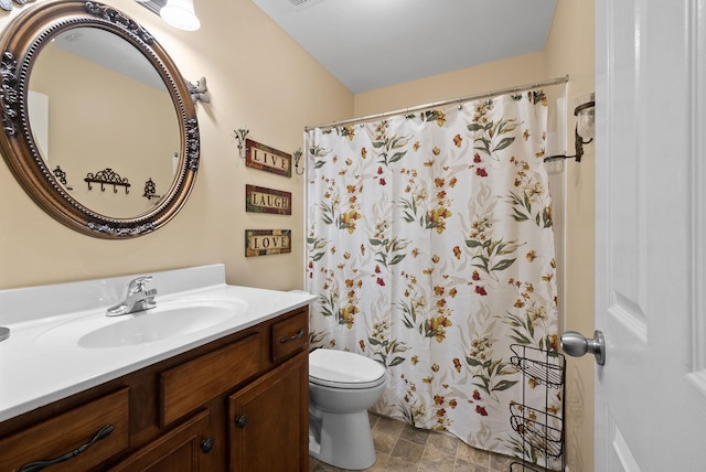 bathroom featuring vanity, stone finish floor, a shower with shower curtain, and toilet