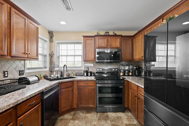 kitchen featuring brown cabinetry, decorative backsplash, stainless steel appliances, and visible vents