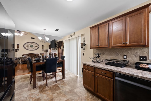 kitchen featuring open floor plan, a chandelier, decorative backsplash, light stone countertops, and hanging light fixtures