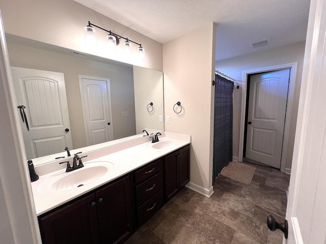 full bathroom with double vanity, visible vents, baseboards, and a sink