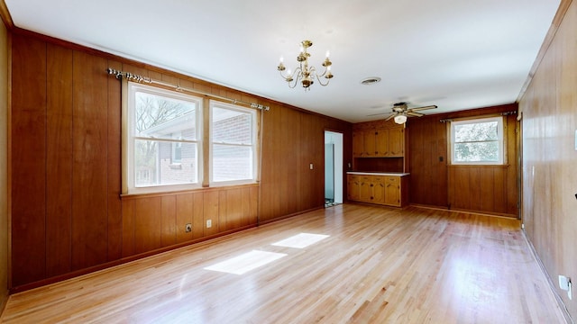1001 Clearview Dr, Mount Juliet, TN 37122 - unfurnished living room featuring wood walls, ceiling fan with notable chandelier, light wood finished floors, baseboards, and visible vents