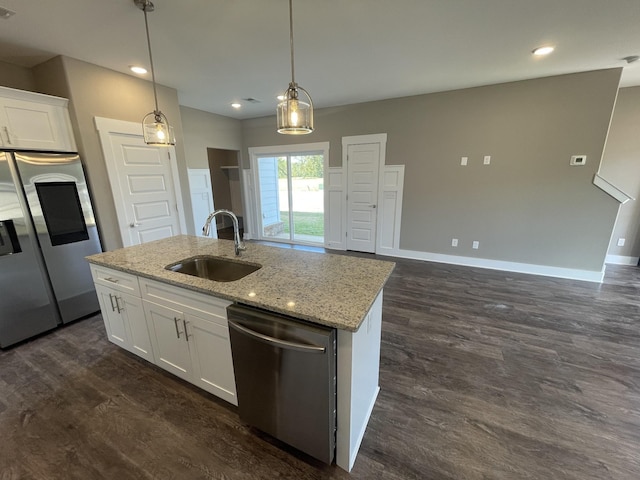 kitchen with stainless steel appliances, a sink, baseboards, a kitchen island with sink, and white cabinetry