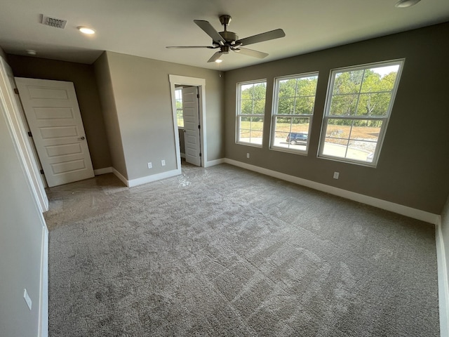 unfurnished bedroom featuring connected bathroom, ceiling fan, carpet floors, baseboards, and visible vents