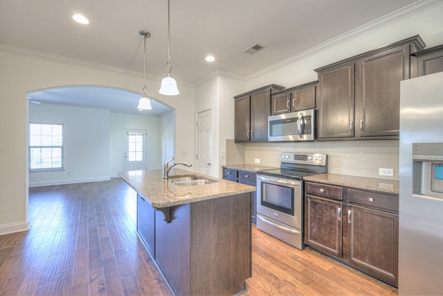 956 Innsbrooke Ave, Hendersonville, TN 37075 - kitchen featuring stainless steel appliances, arched walkways, a sink, light stone countertops, and an island with sink