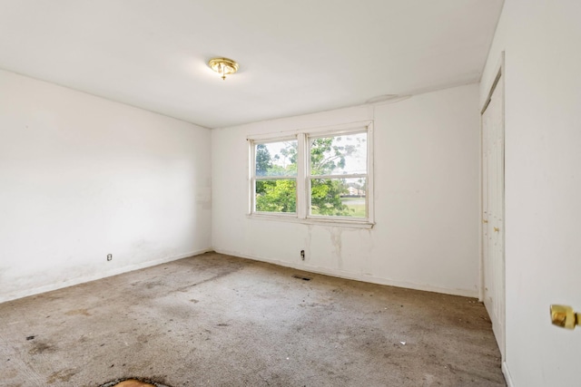empty room featuring visible vents, carpet flooring, and baseboards