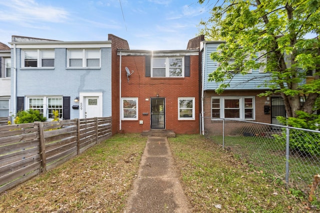 view of property featuring brick siding and fence private yard