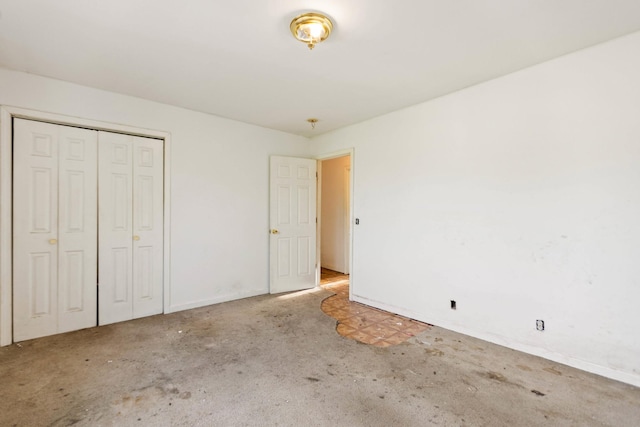 unfurnished bedroom featuring baseboards, carpet flooring, and a closet