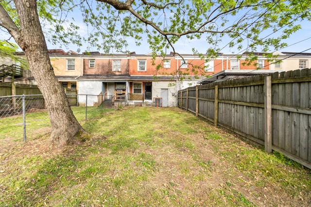back of property featuring a fenced backyard, a yard, and central AC unit