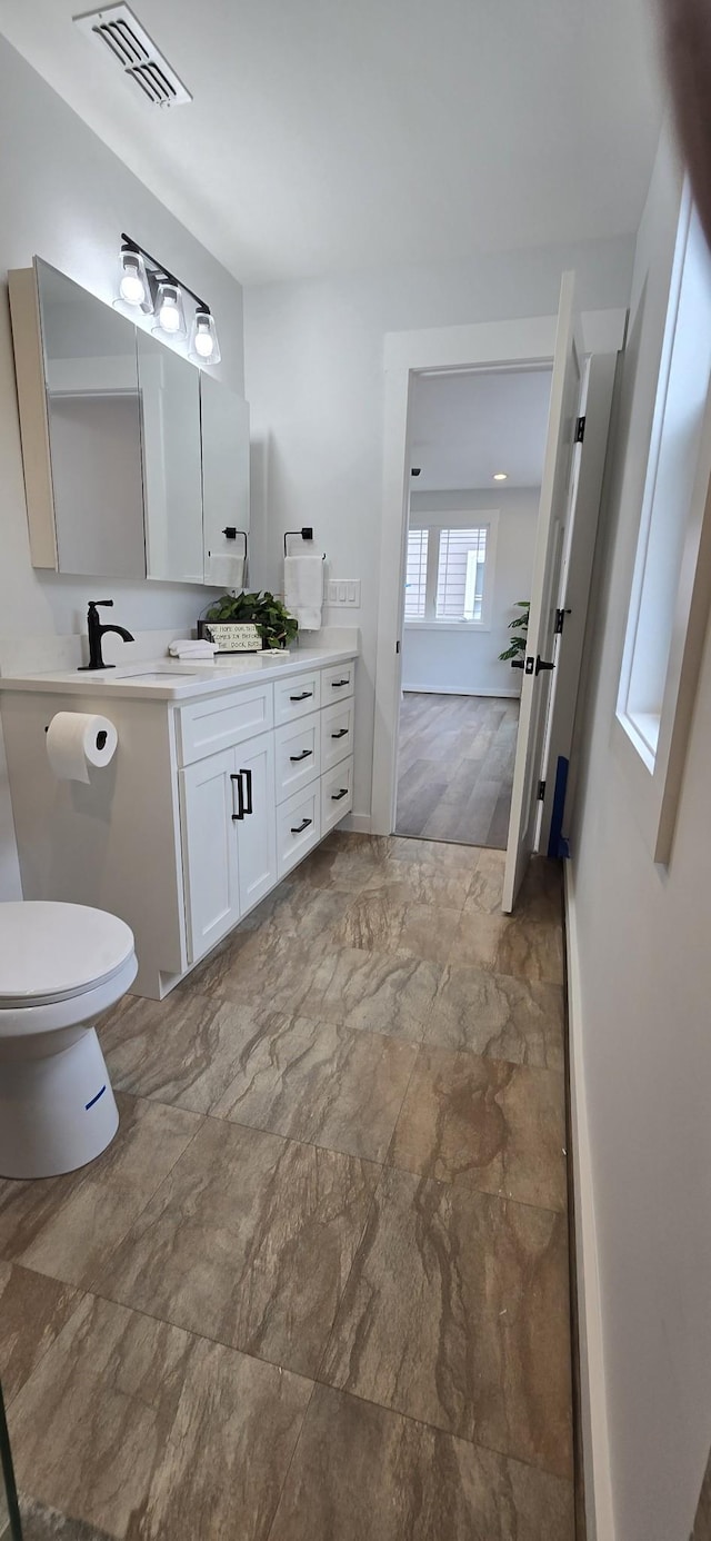 bathroom with visible vents, toilet, and vanity
