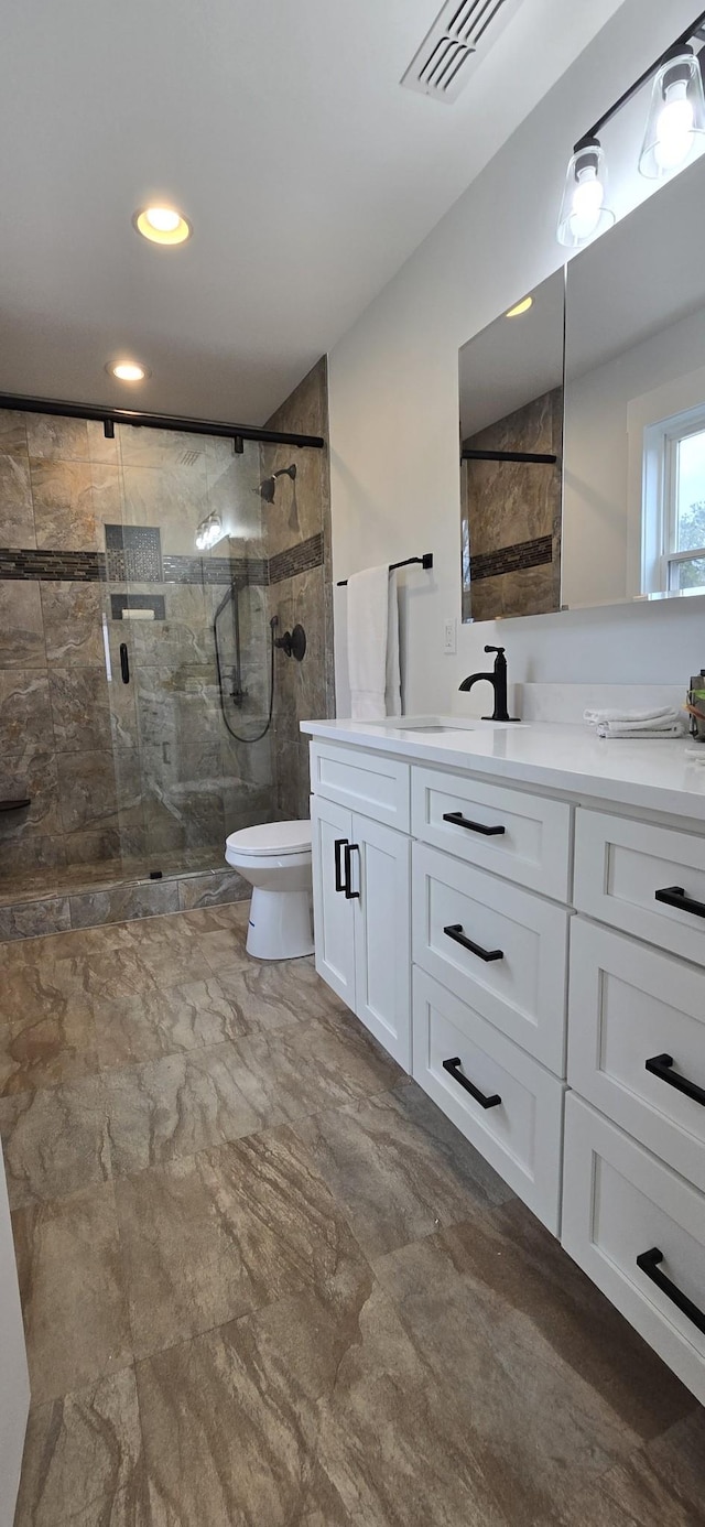 bathroom with a stall shower, vanity, marble finish floor, toilet, and recessed lighting