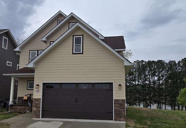 exterior space with a garage, driveway, and stone siding