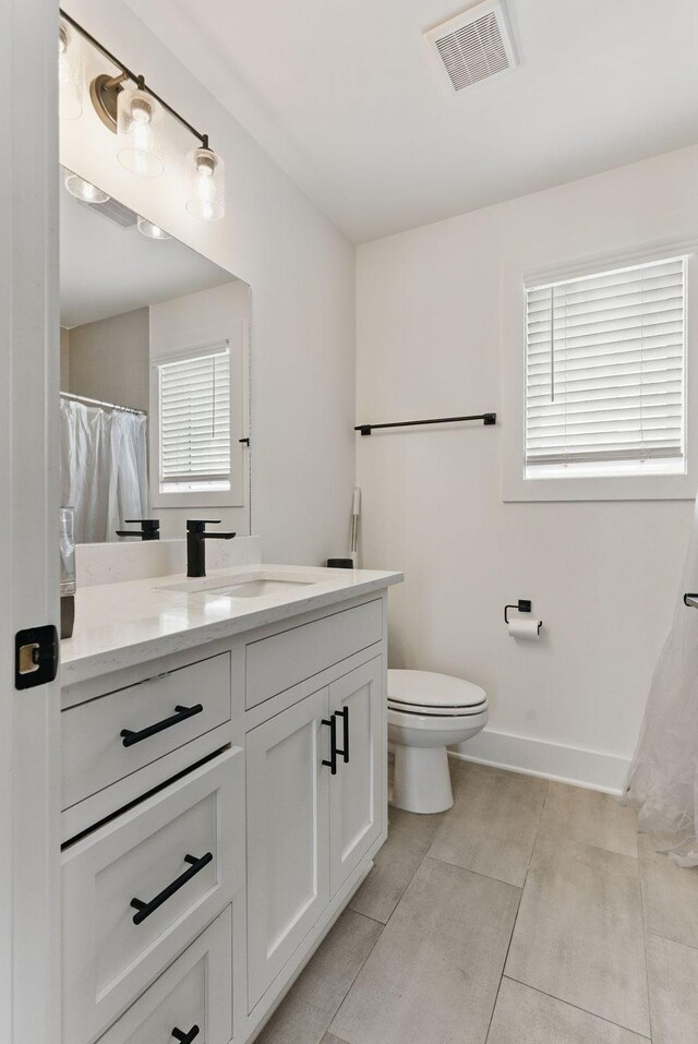 2002 Manchester Ave, Nashville, TN 37218 - full bath featuring visible vents, toilet, vanity, and a healthy amount of sunlight