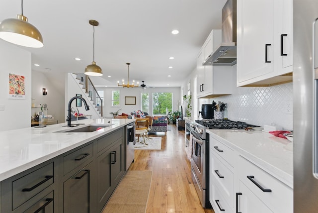 2006 Manchester Ave, Nashville, TN 37218 - kitchen with a sink, stainless steel appliances, light wood-style flooring, white cabinets, and wall chimney exhaust hood