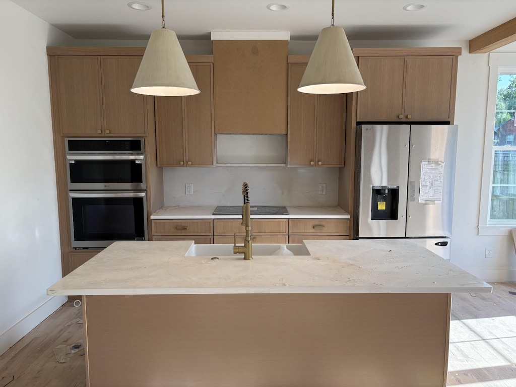 kitchen featuring appliances with stainless steel finishes, light countertops, and light wood-type flooring