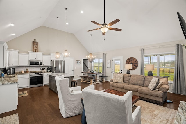 living area with ceiling fan with notable chandelier, dark wood-style floors, and high vaulted ceiling