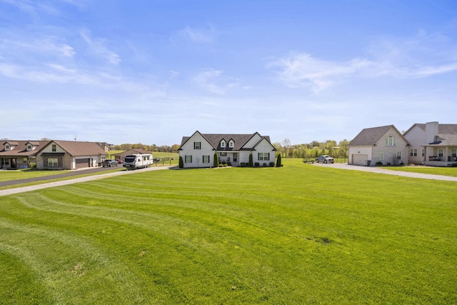 view of front facade featuring a garage, a residential view, driveway, and a front lawn