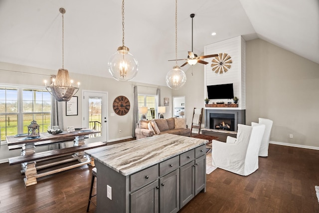 kitchen with gray cabinets, baseboards, dark wood-style flooring, and a breakfast bar area