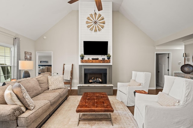 living room featuring wood finished floors, a large fireplace, ceiling fan, and high vaulted ceiling