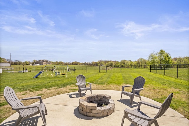 view of patio with a fenced backyard, a playground, and an outdoor fire pit