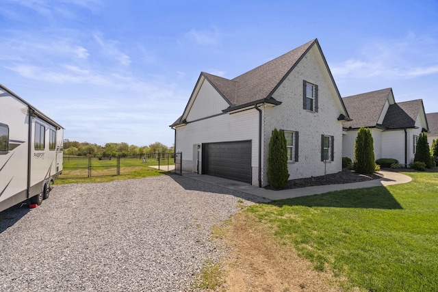 view of property exterior with driveway, fence, a garage, brick siding, and a lawn