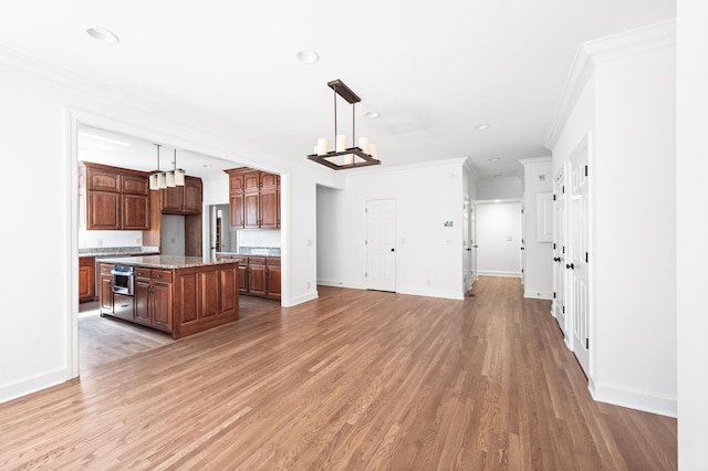 1008 Green Hill Cv, Brentwood, TN 37027 - kitchen with a center island, baseboards, ornamental molding, and light wood finished floors