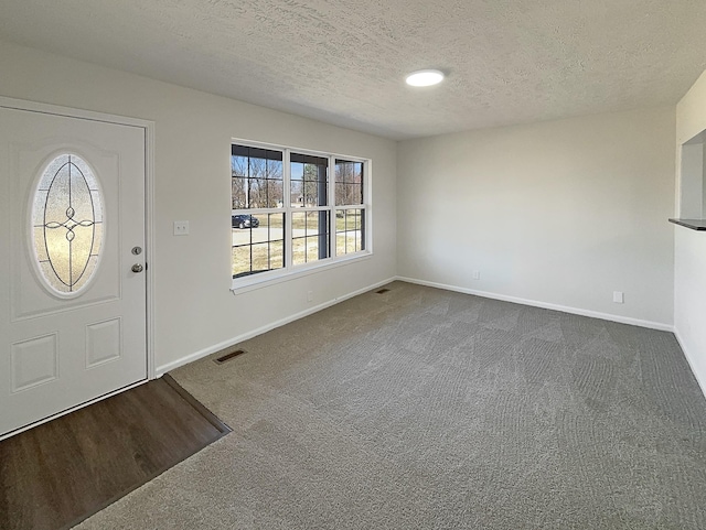 958 Clearview Rd, Cottontown, TN 37048 - foyer entrance featuring a textured ceiling, dark colored carpet, visible vents, and baseboards
