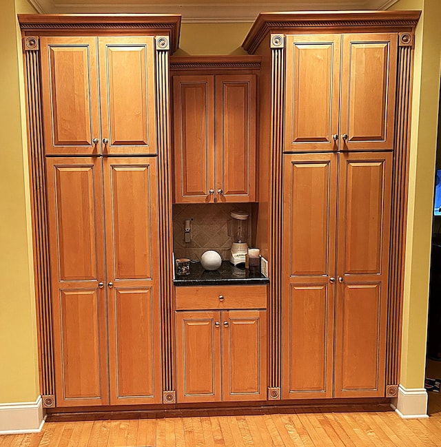 247 Woods Ferry Cir, Gallatin, TN 37066 - kitchen featuring light wood-style floors, backsplash, dark stone countertops, baseboards, and brown cabinets