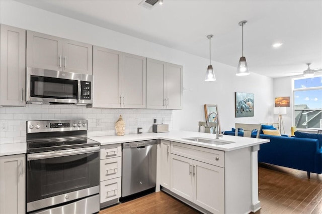 1638 54th Ave N Unit 320, Nashville, TN 37209 - kitchen featuring dark wood-style floors, a sink, appliances with stainless steel finishes, and tasteful backsplash