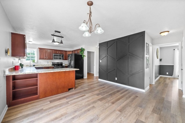 3051 Outfitters Dr, Clarksville, TN 37040 - kitchen featuring a sink, light wood-type flooring, baseboards, a peninsula, and appliances with stainless steel finishes