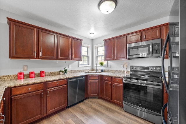 3051 Outfitters Dr, Clarksville, TN 37040 - kitchen with light wood finished floors, stainless steel appliances, light stone countertops, and a sink