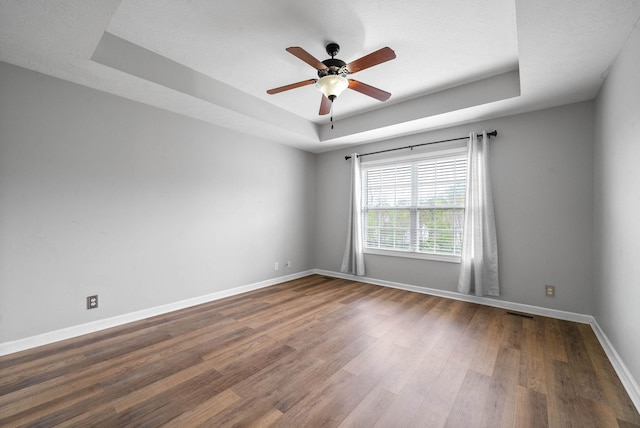3051 Outfitters Dr, Clarksville, TN 37040 - empty room featuring ceiling fan, a raised ceiling, baseboards, dark wood-type flooring, and visible vents