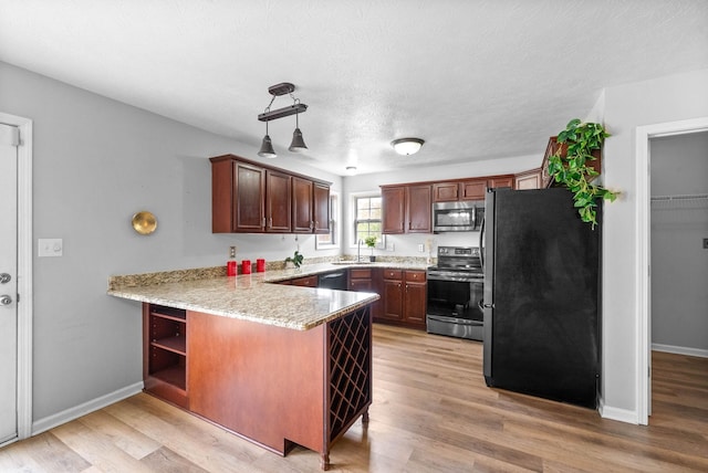 3051 Outfitters Dr, Clarksville, TN 37040 - kitchen with stainless steel appliances, a peninsula, a sink, and light wood-style floors